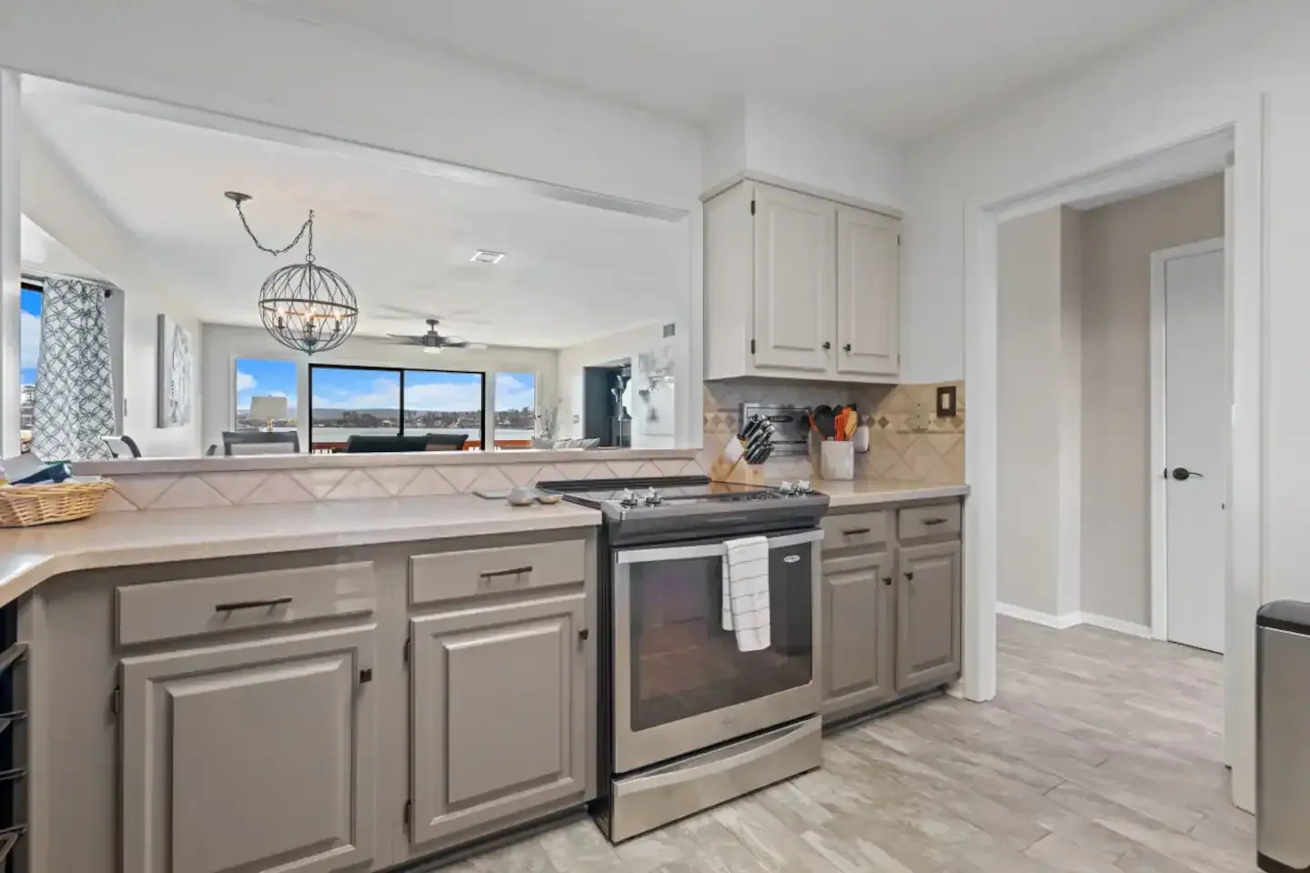 A kitchen with stainless steel appliances and gray cabinets.