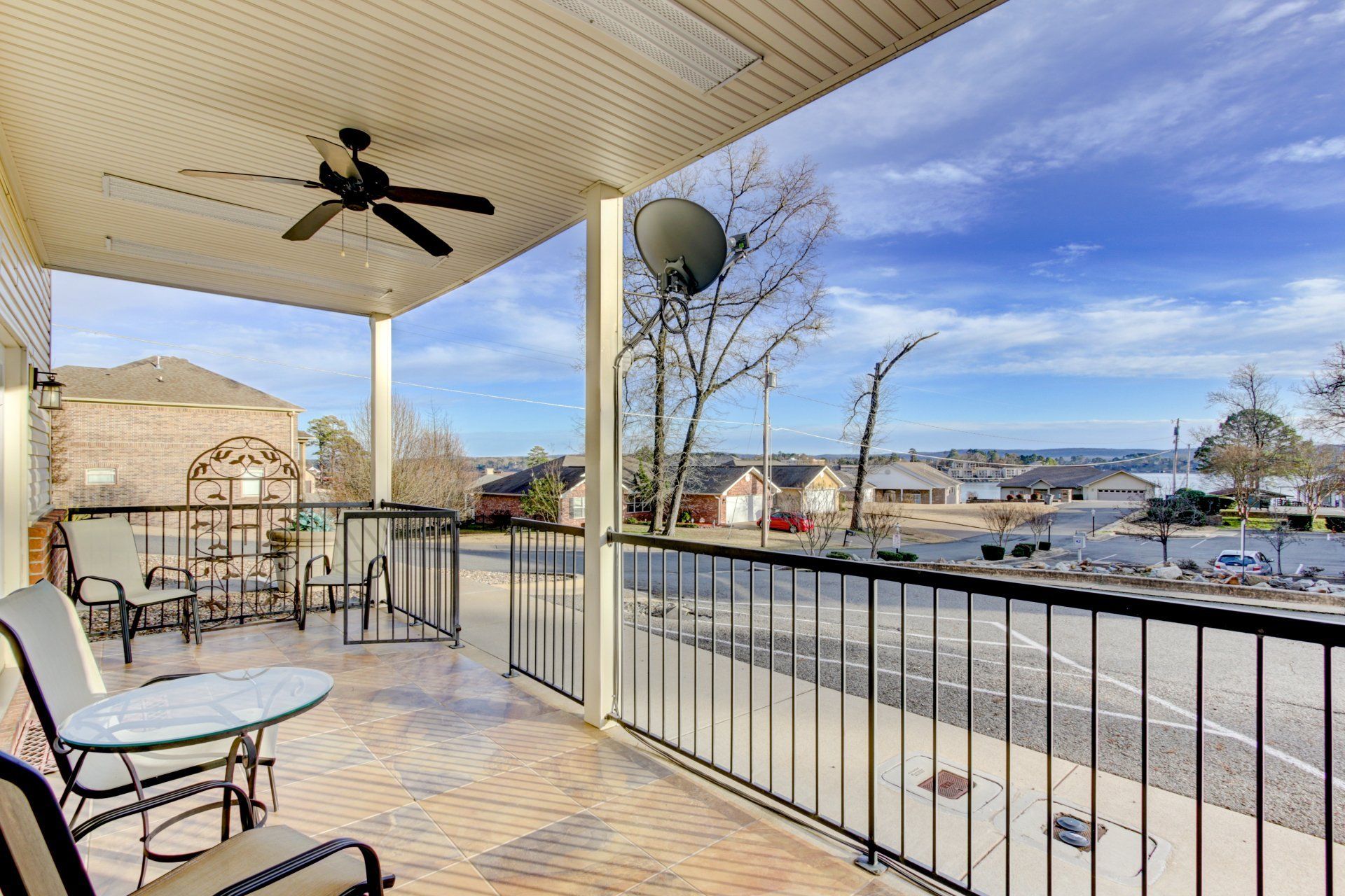 A balcony with a ceiling fan and a view of a city.