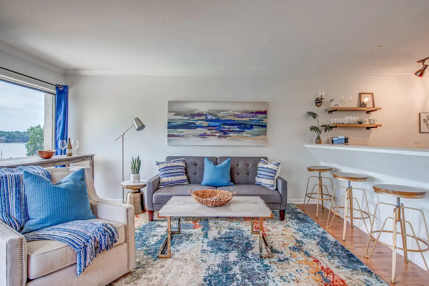A living room with a couch , chair , coffee table and rug.
