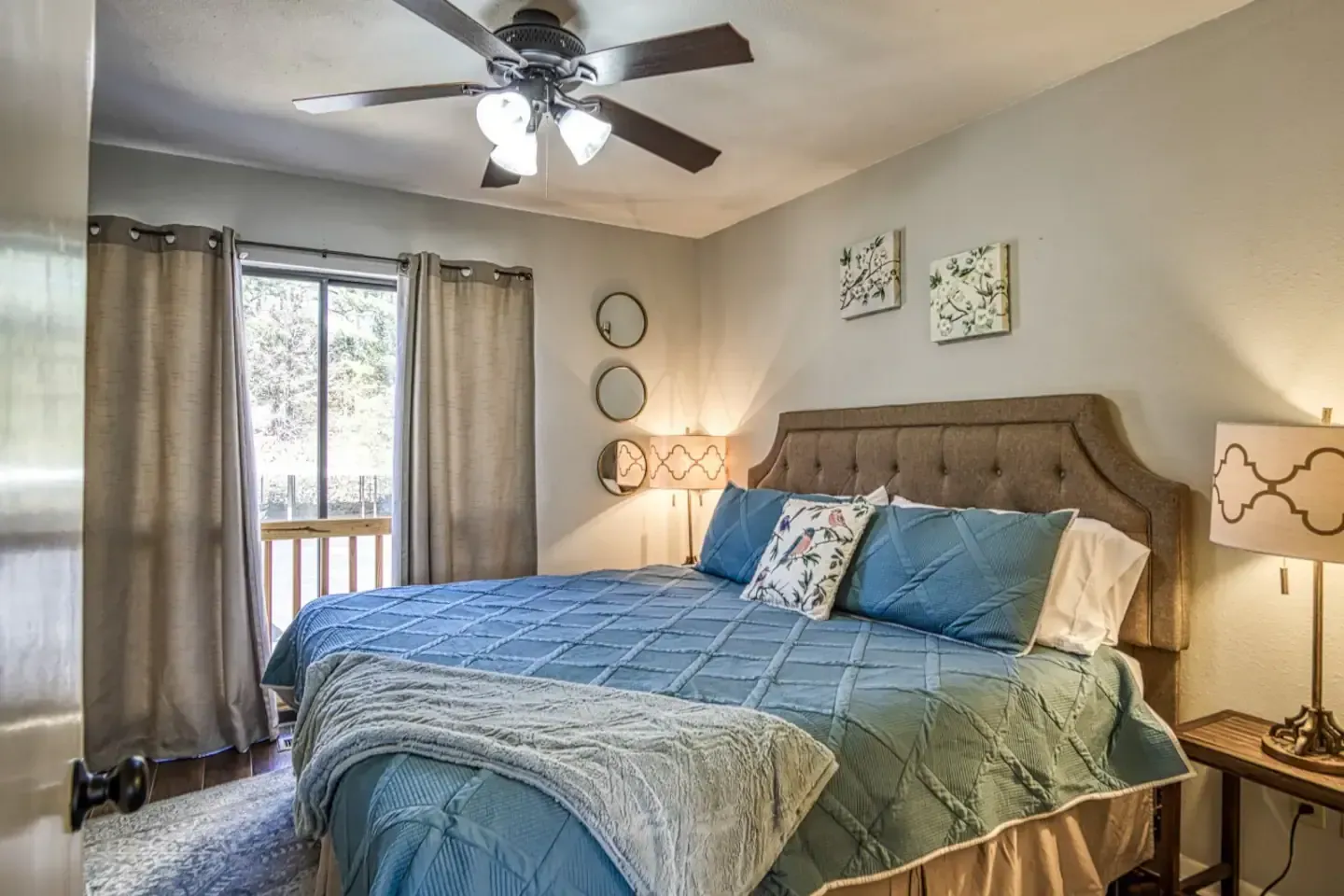 A bedroom with a king size bed and a ceiling fan.
