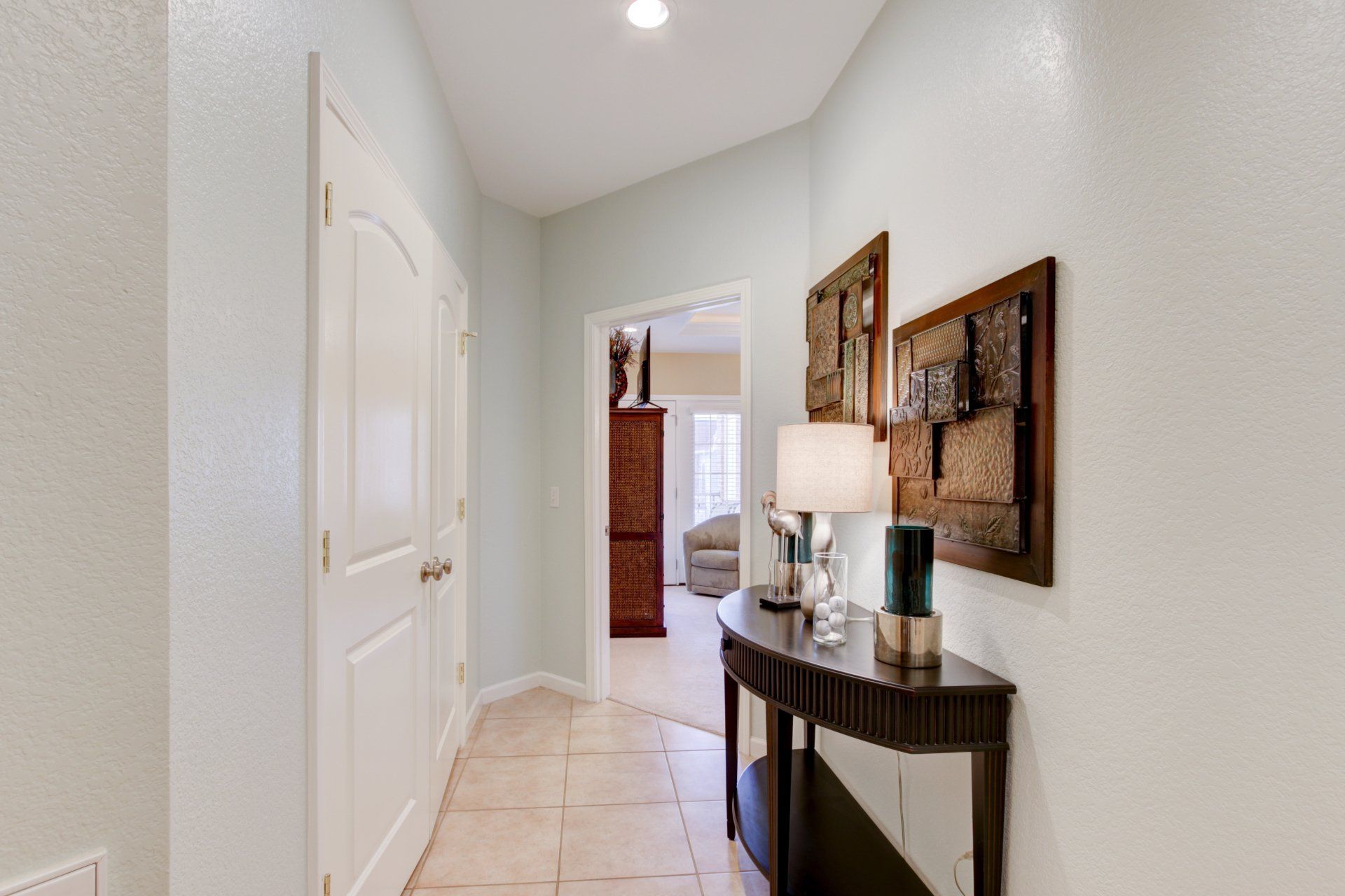 A hallway in a house with a table and lamps.