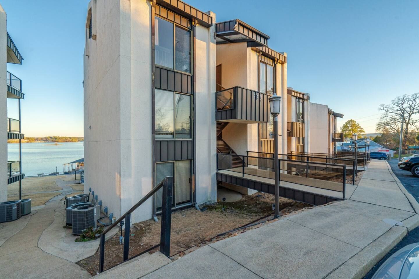 A building with stairs leading up to it is next to a body of water.