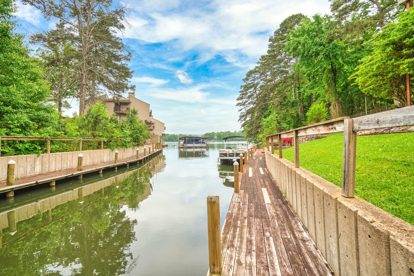 A wooden dock leading to a body of water surrounded by trees.