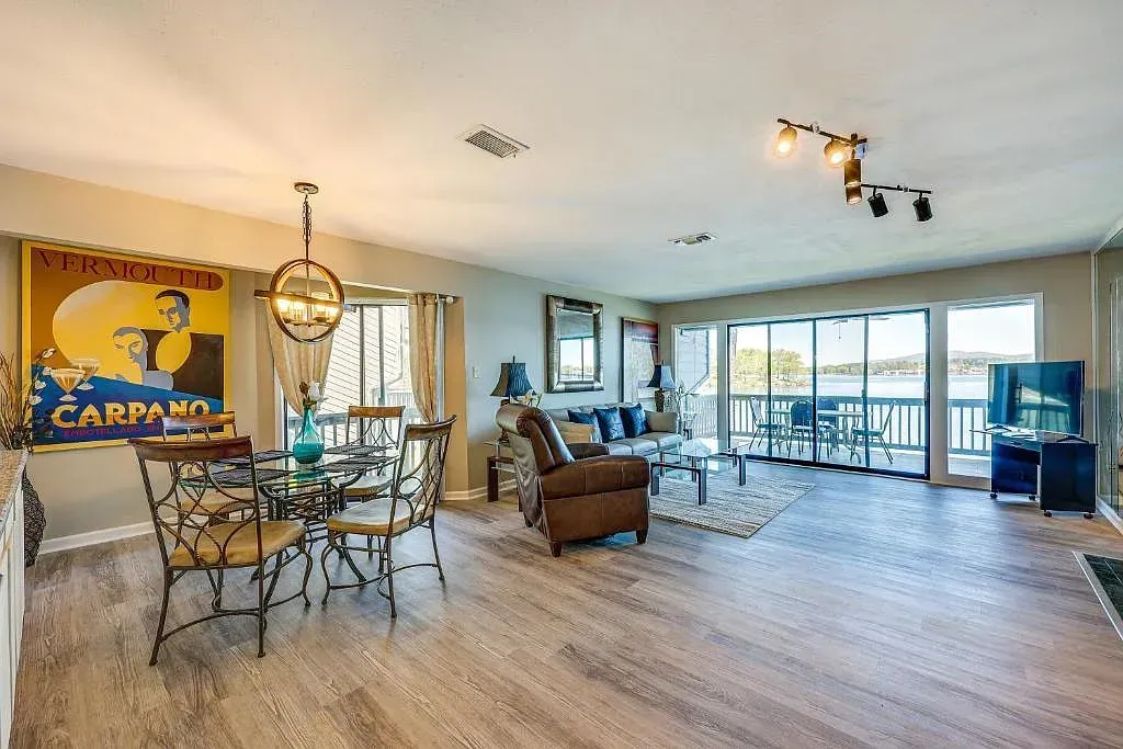 A living room with a dining table and chairs and a large window.