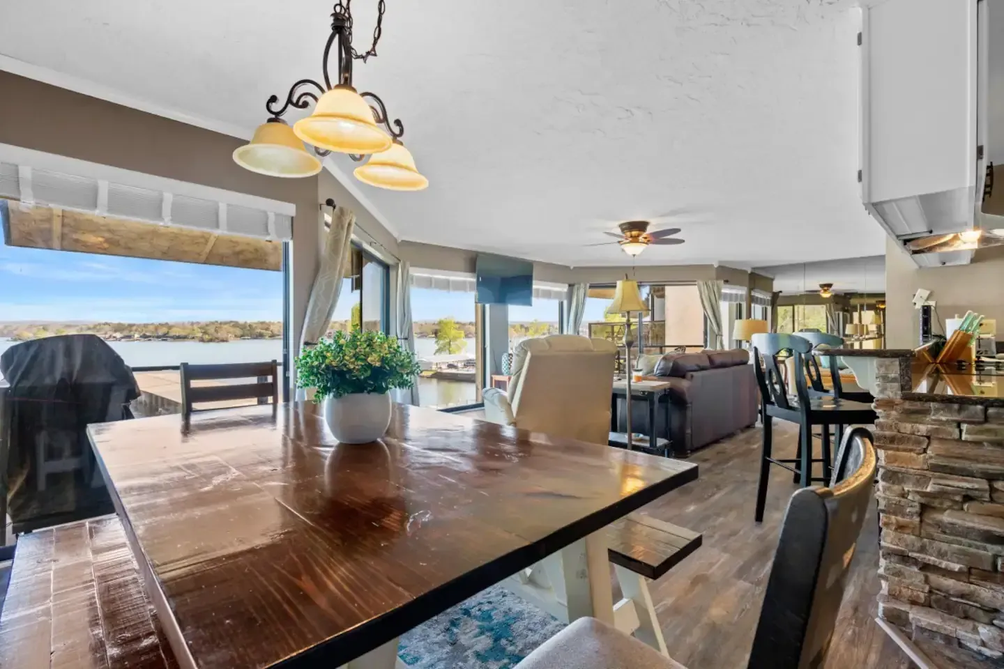 A dining room table and chairs in a house with a view of a lake.