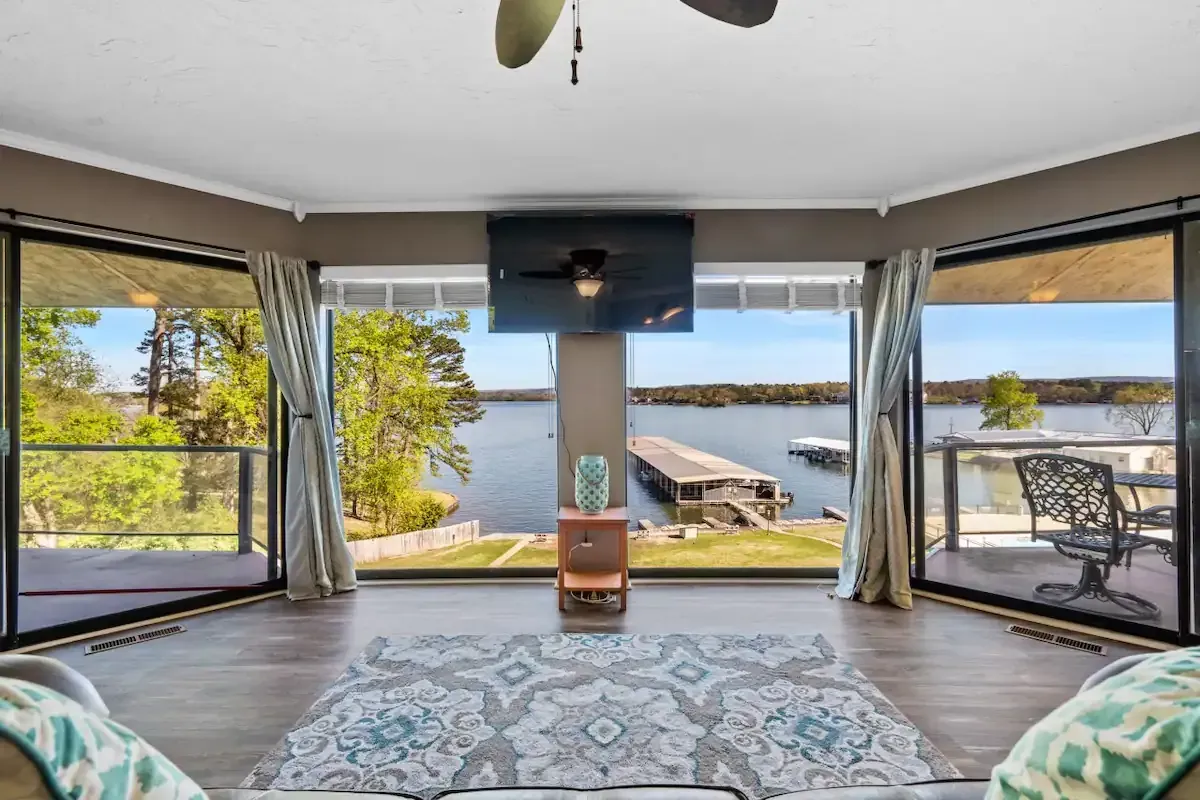 A living room with a view of a lake and a ceiling fan.