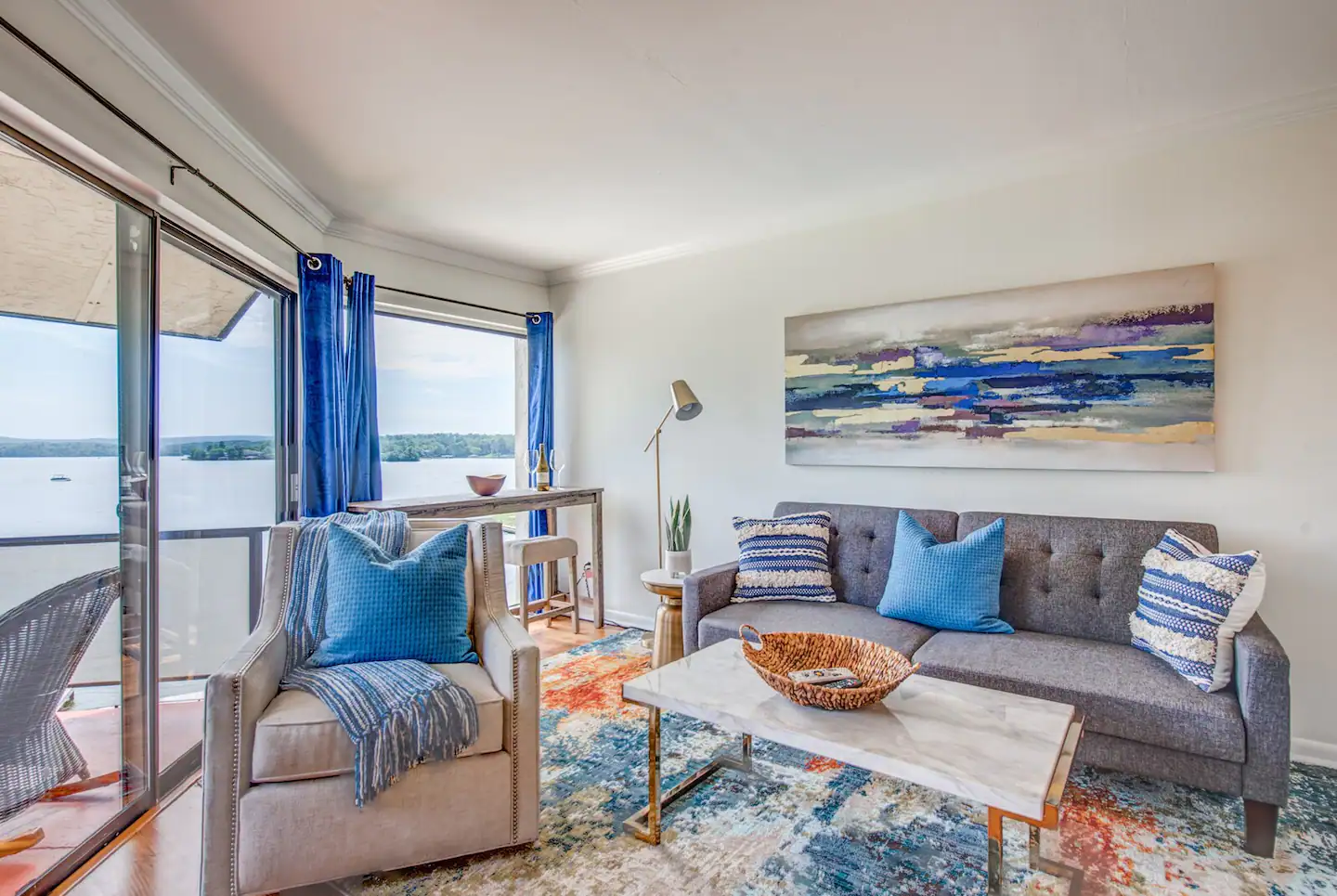 A living room with a couch , chair , coffee table and sliding glass doors.