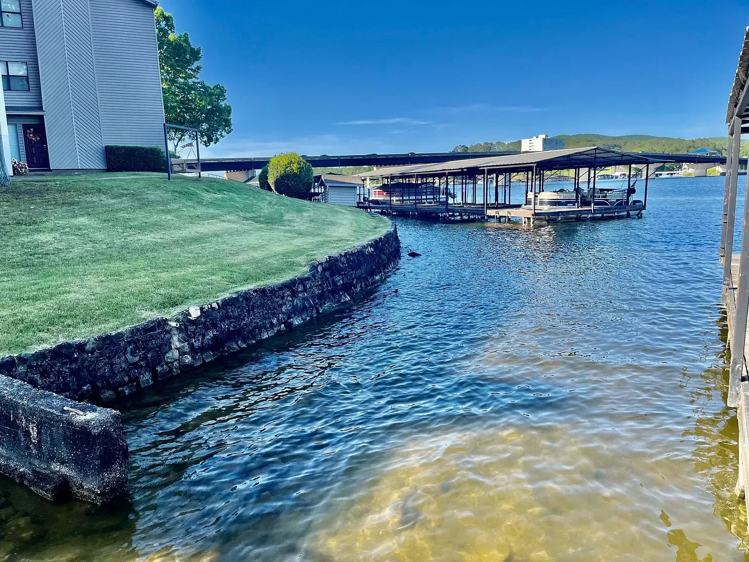 A large body of water with a dock and a building in the background.