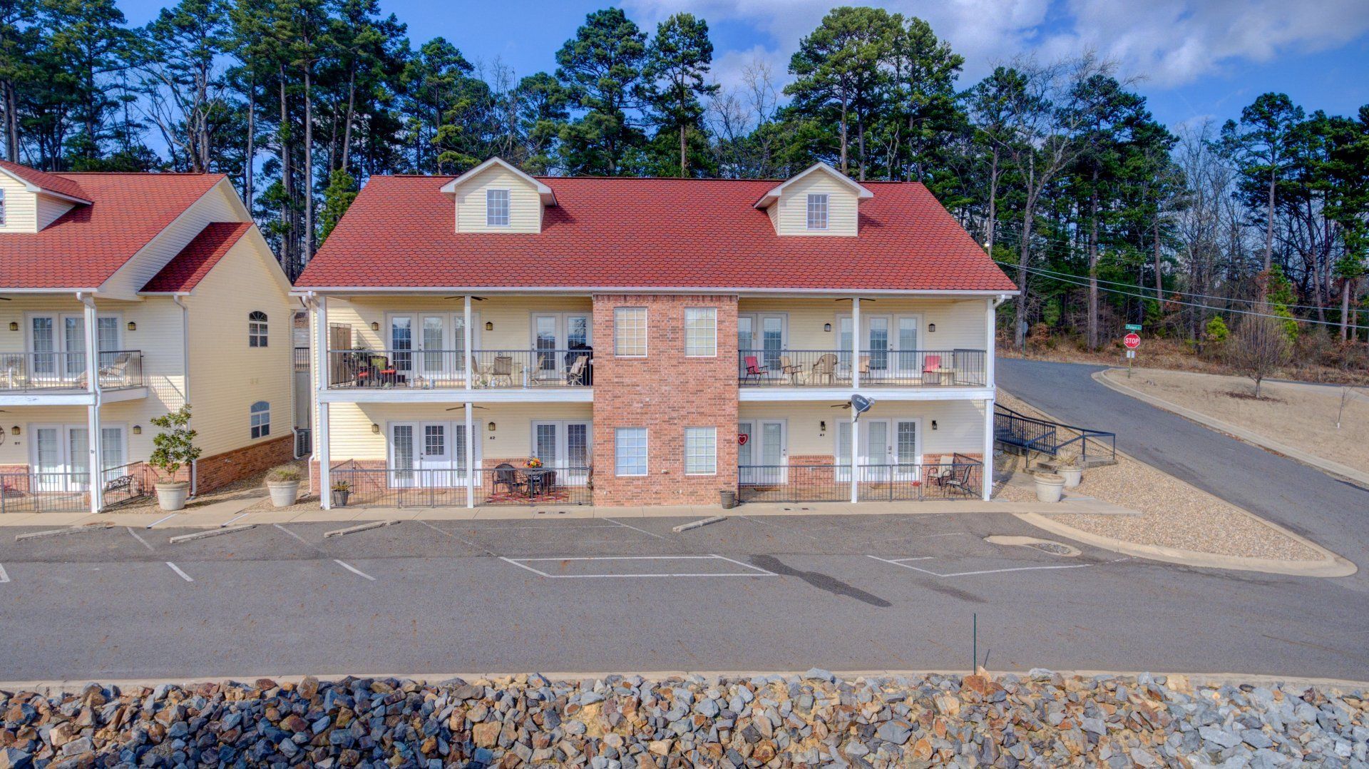 A row of houses with red roofs are sitting next to each other in a parking lot.