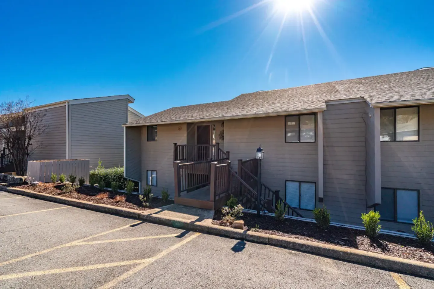A large apartment building with a parking lot in front of it.