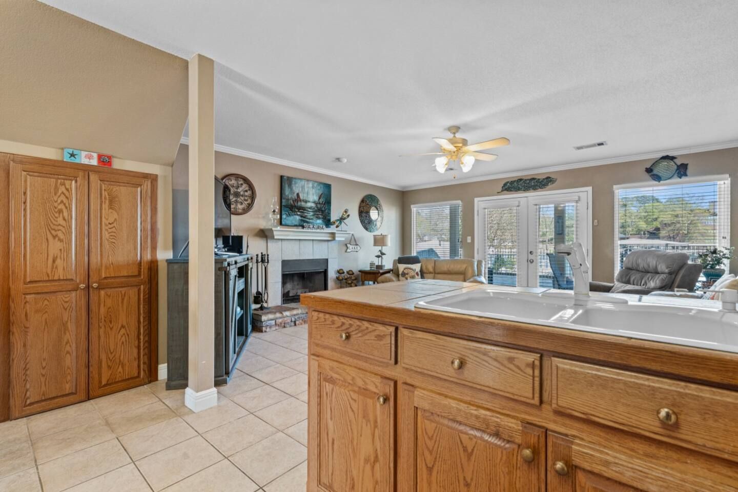 A kitchen with a sink , cabinets , drawers and a ceiling fan.
