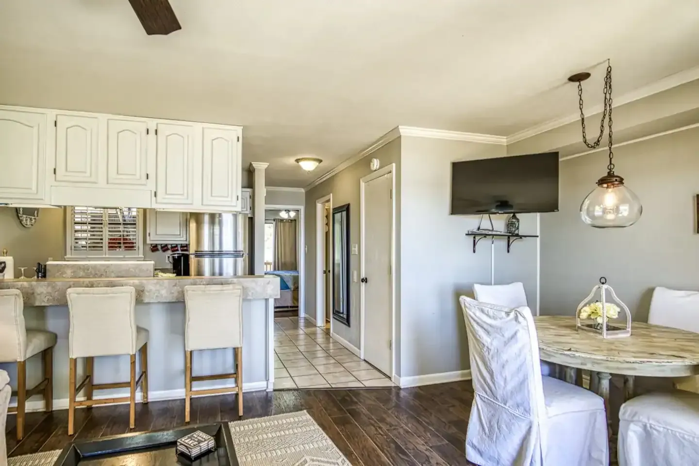 A living room with a table and chairs and a flat screen tv.
