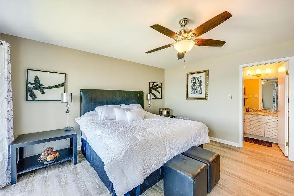 A bedroom with a large bed and a ceiling fan.