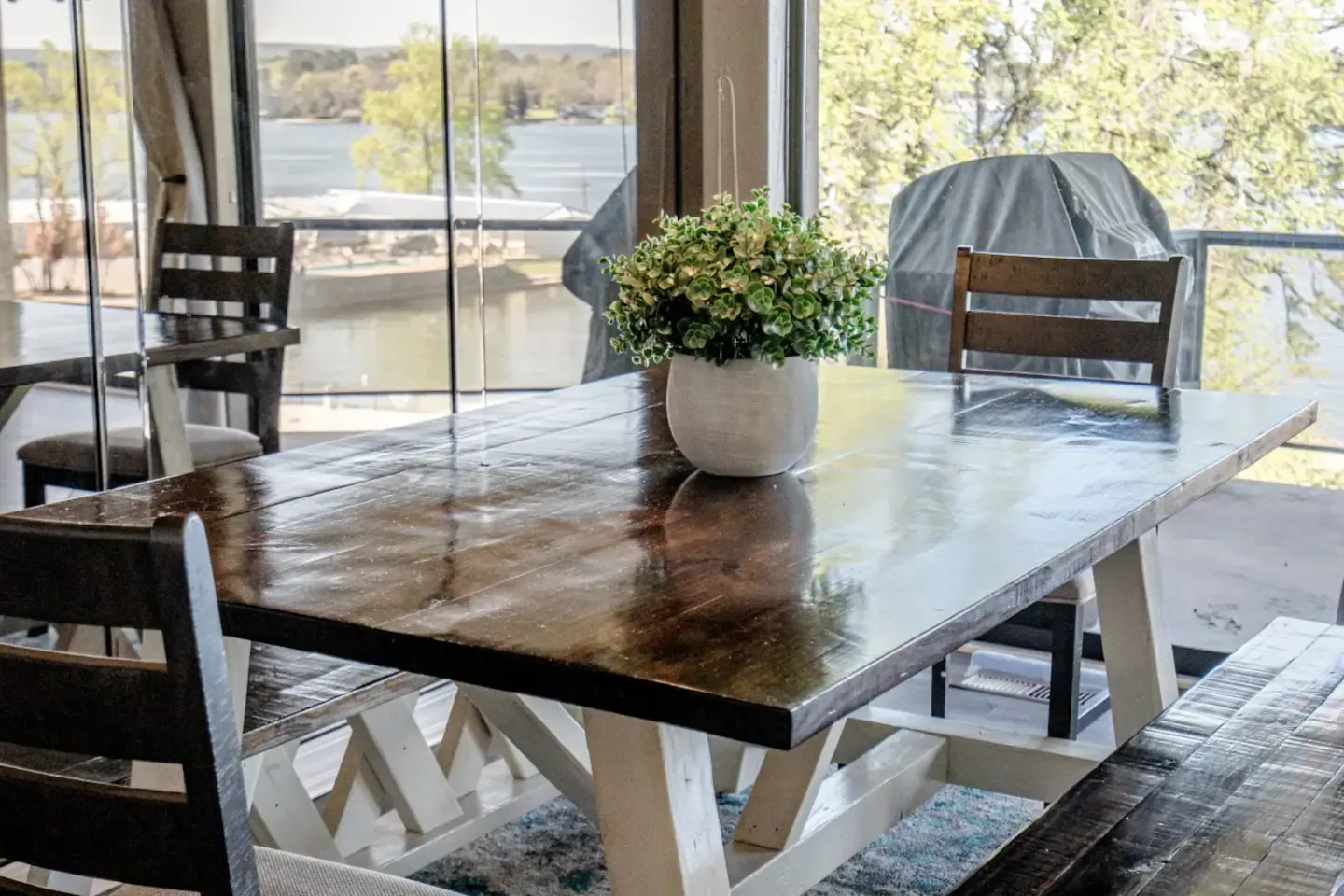 A dining room table with a vase of flowers on top of it.
