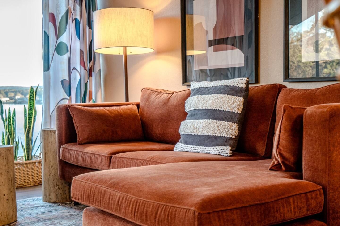 A living room with a red sectional couch and a lamp.