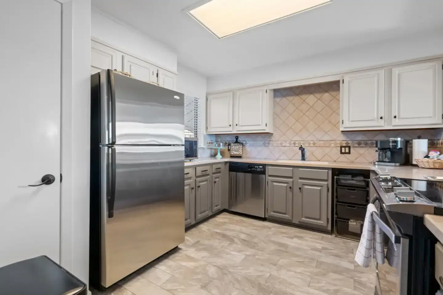 A kitchen with stainless steel appliances and white cabinets.