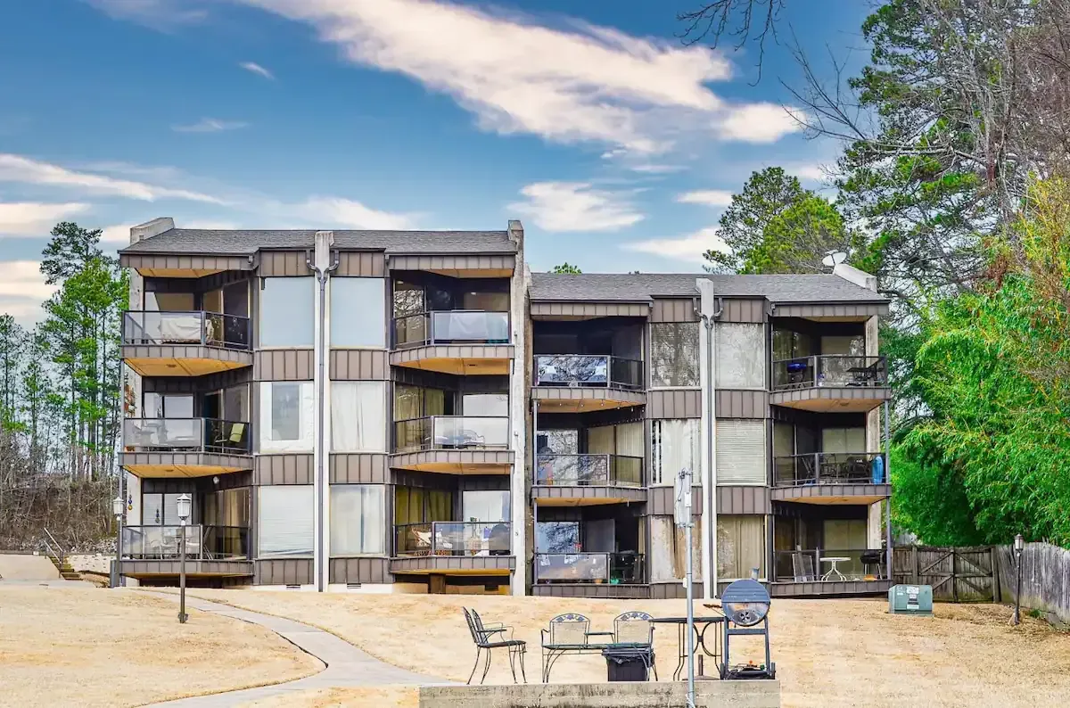 A large apartment building with a fire pit in front of it.