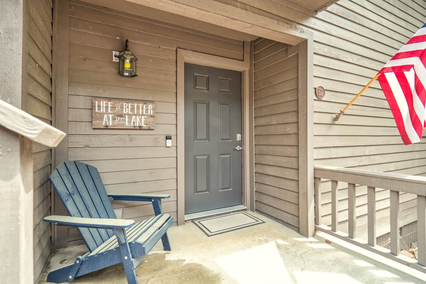 A porch with a chair and an american flag on it