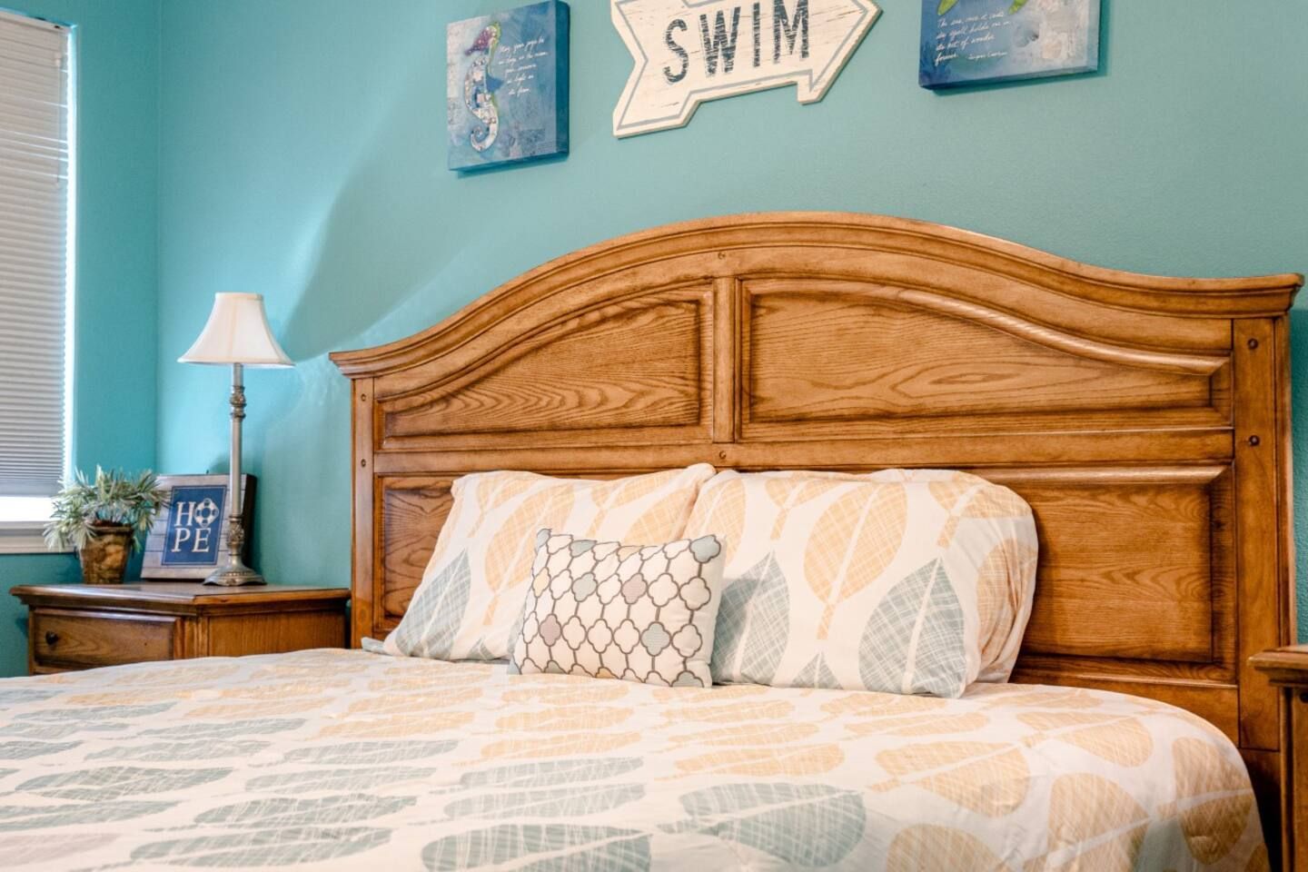 There is a sign on the wall above the bed that says swim.