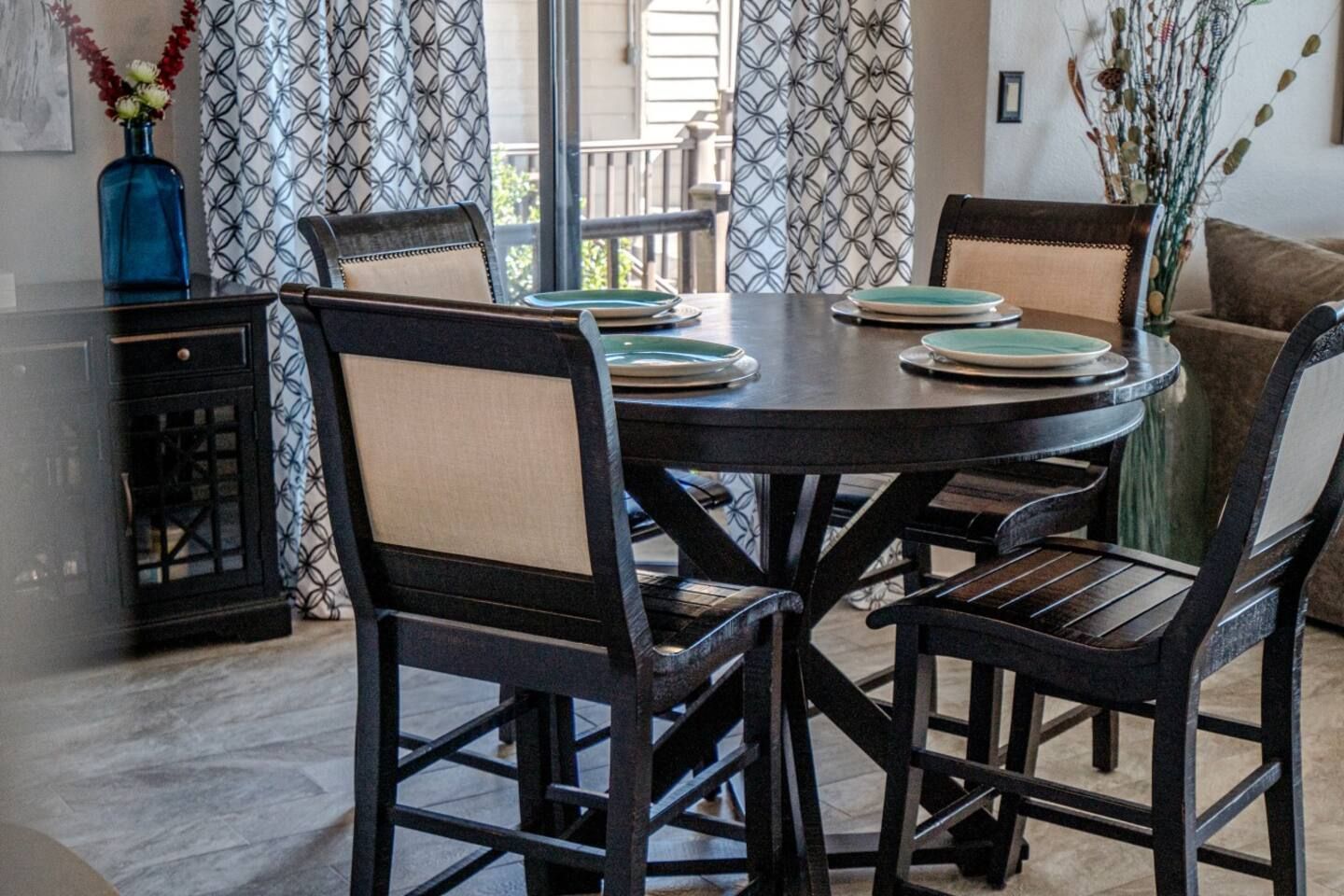 A dining room table with four chairs and plates on it.