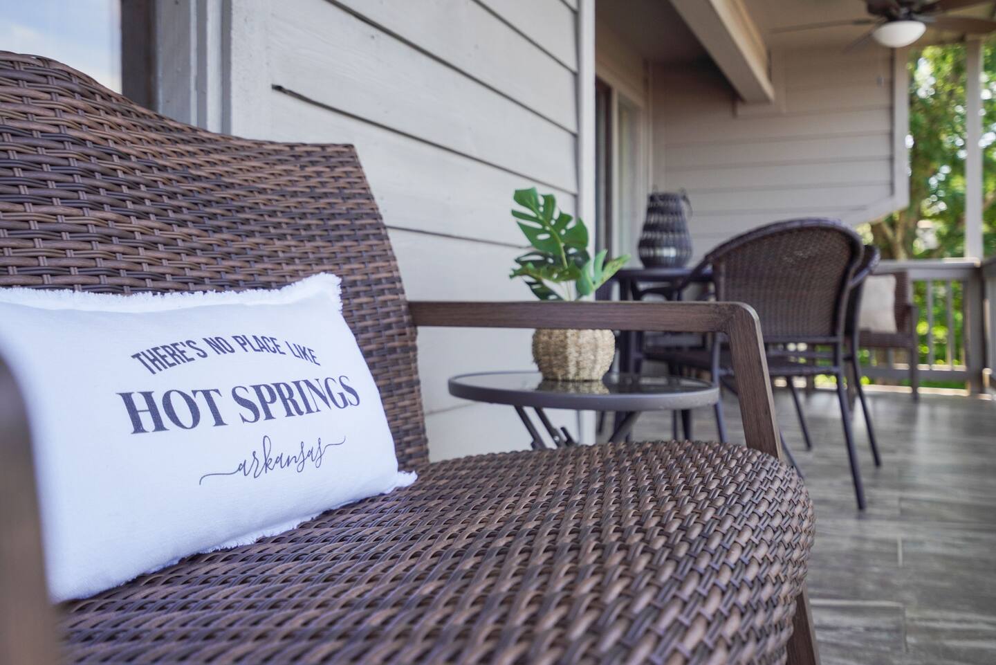 A wicker chair with a pillow on it that says hot springs