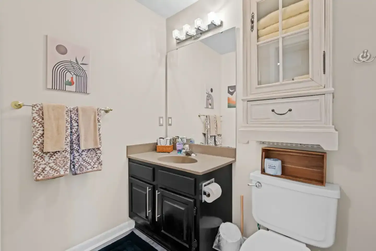 A bathroom with a sink , toilet and mirror.