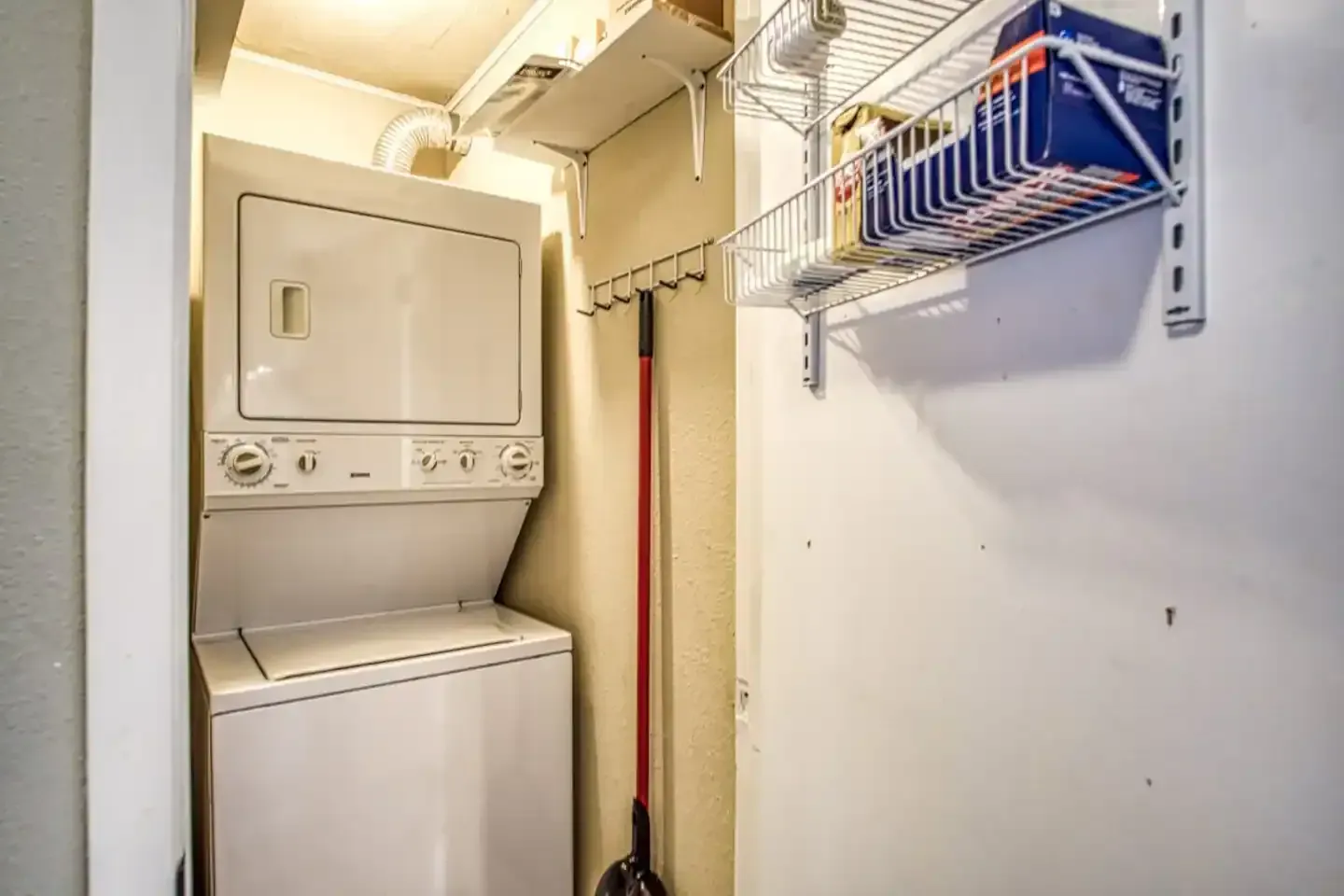 A washer and dryer are stacked on top of each other in a laundry room.