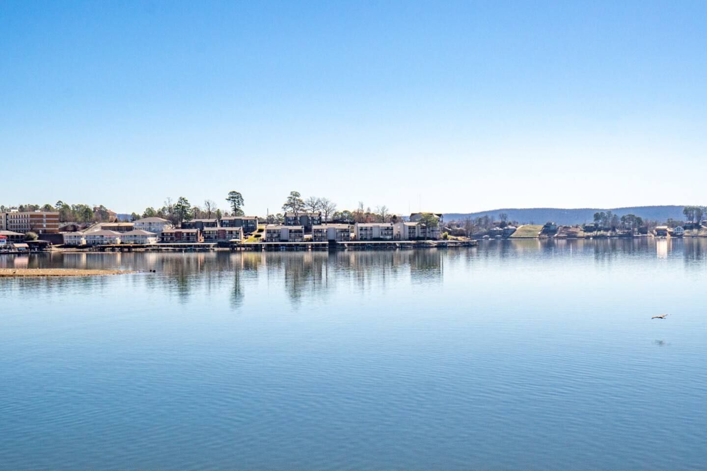 A large body of water surrounded by houses on a sunny day.