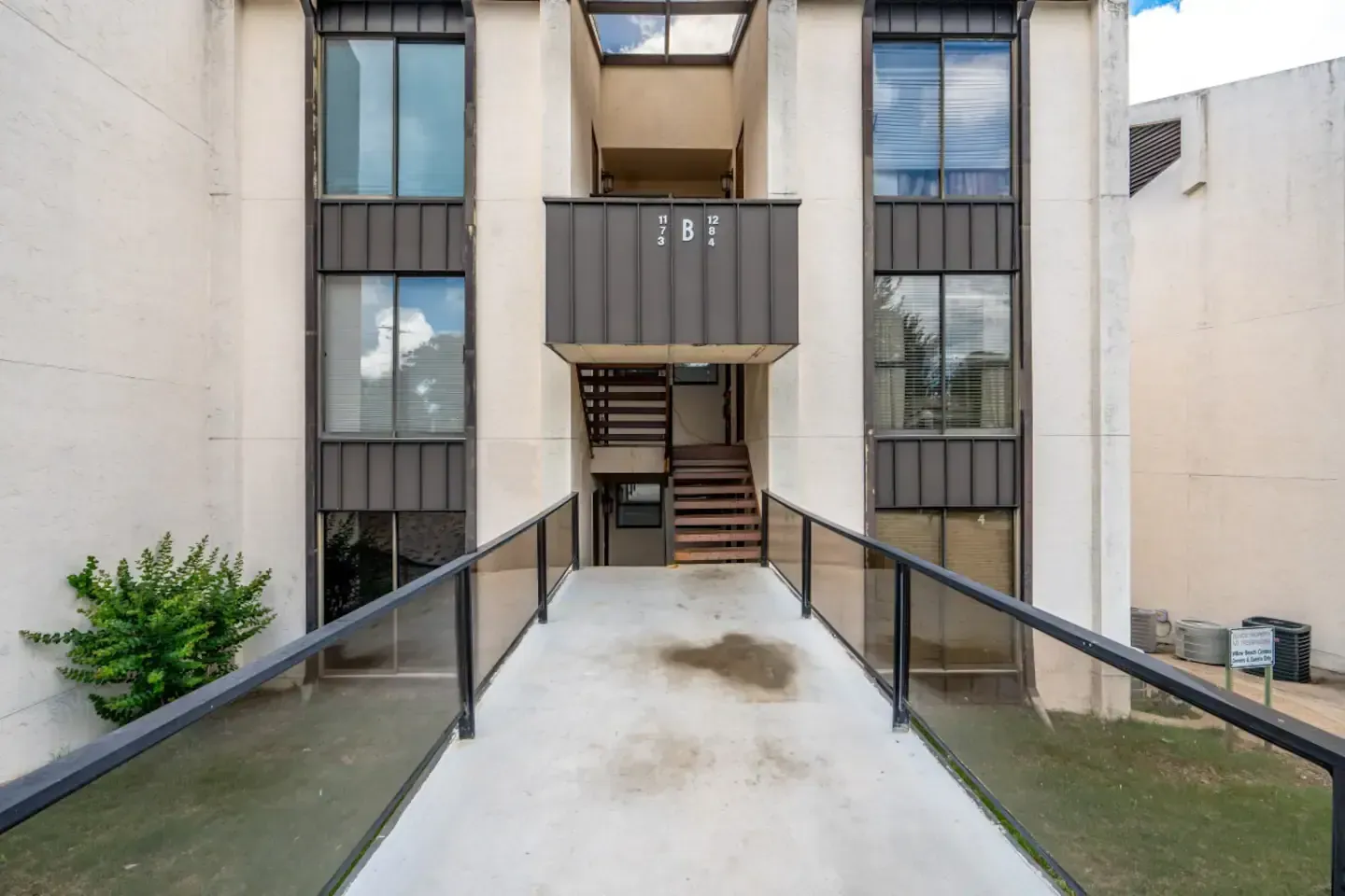 A building with stairs and a ramp leading to it.