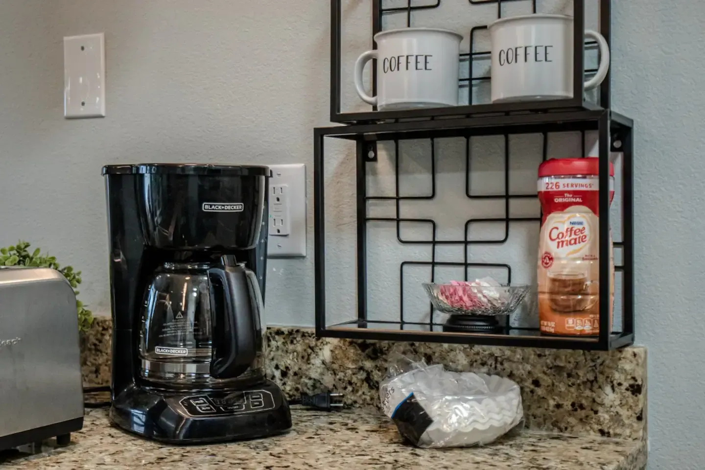 A coffee maker is sitting on a counter next to a toaster.