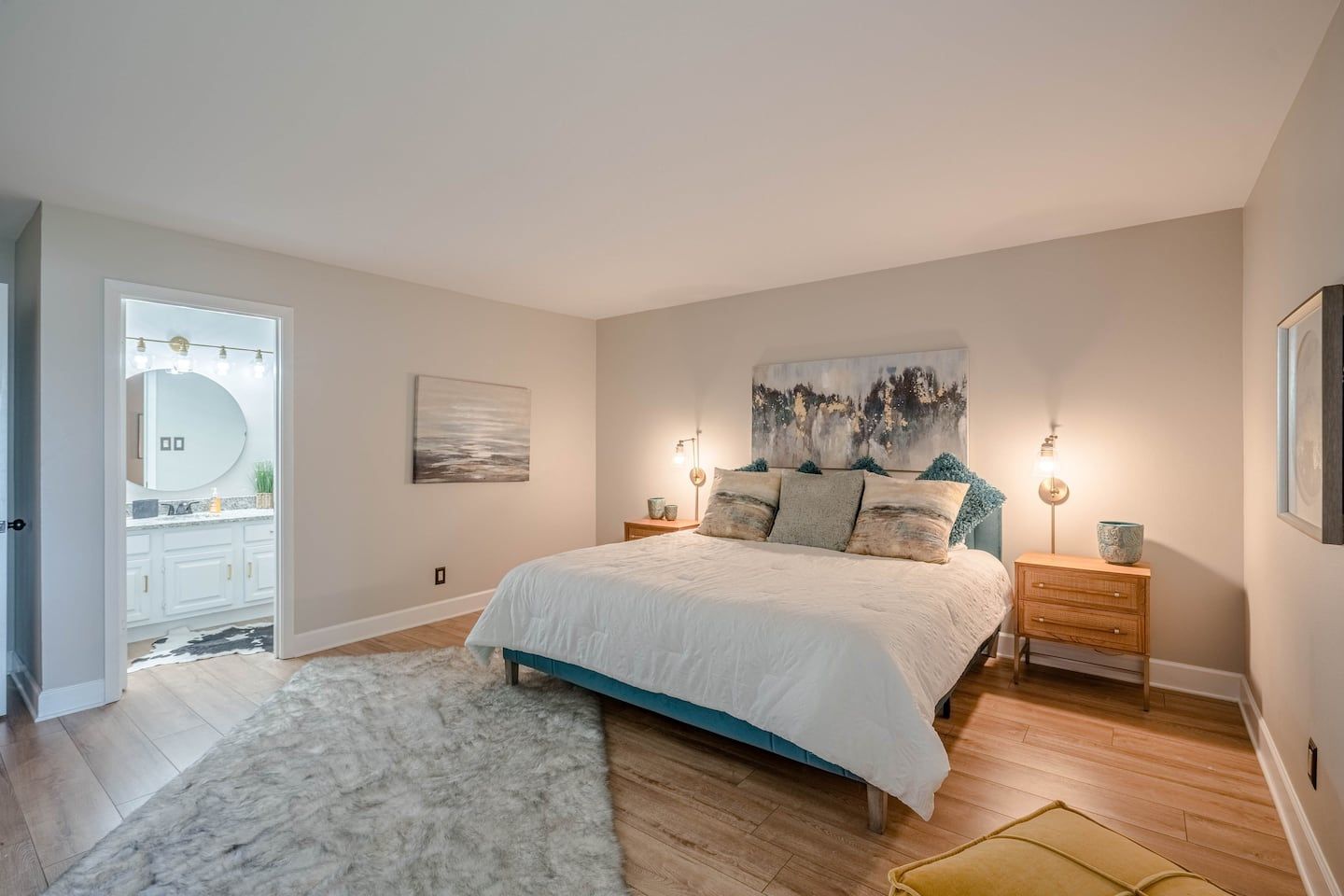 A bedroom with a large bed , nightstands , and a rug.