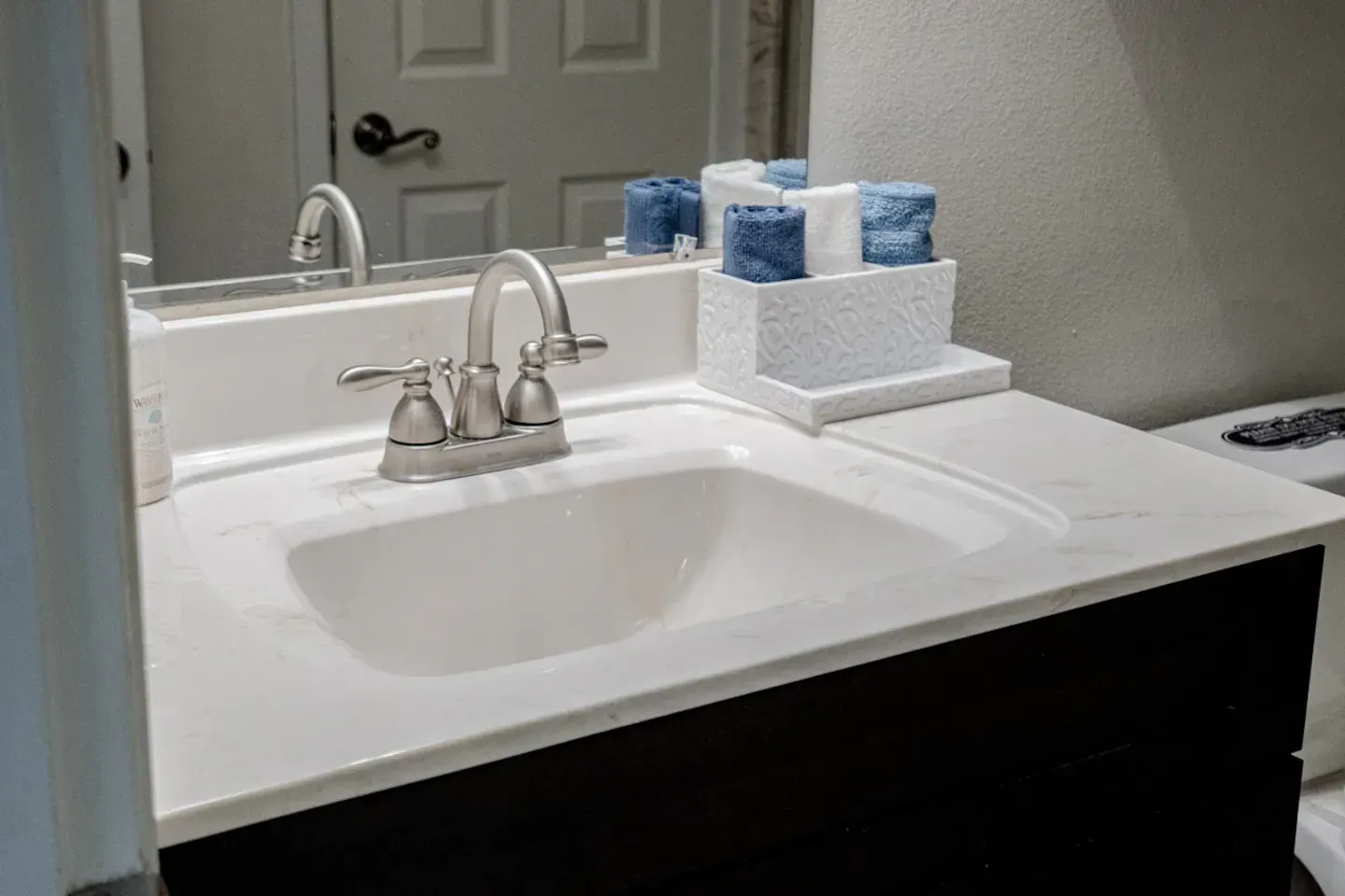 A bathroom with a sink , toilet and mirror.