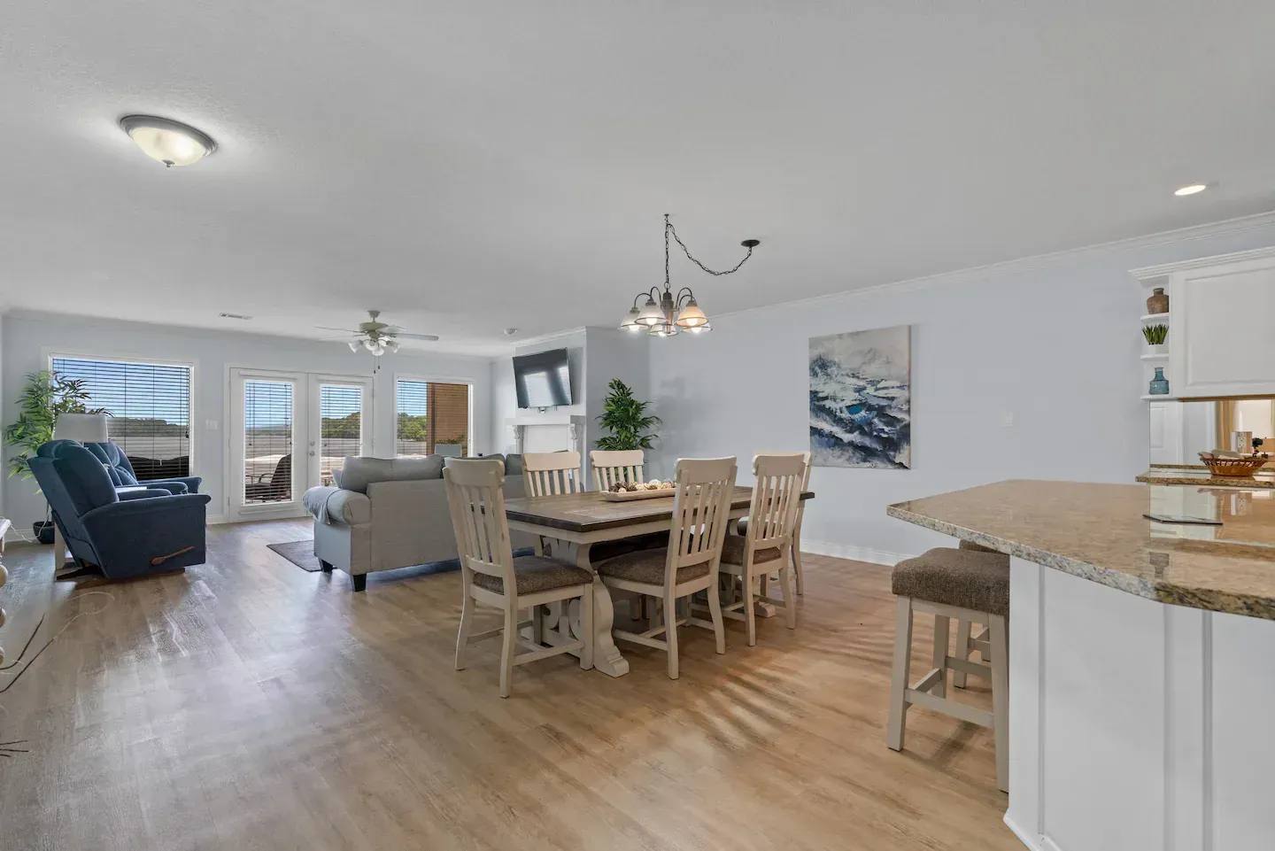 A living room with a dining table and chairs and a kitchen.