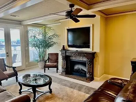 A living room with a fireplace , couch , chairs , table and television.