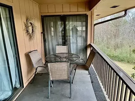 There is a balcony with a table and chairs on it.