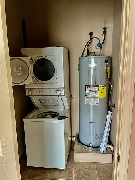 A laundry room with a washer and dryer and a water heater.