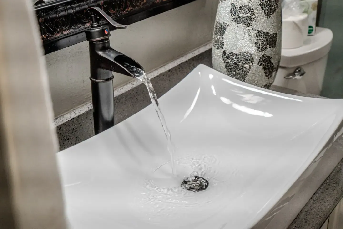 A bathroom sink with water running from a faucet.