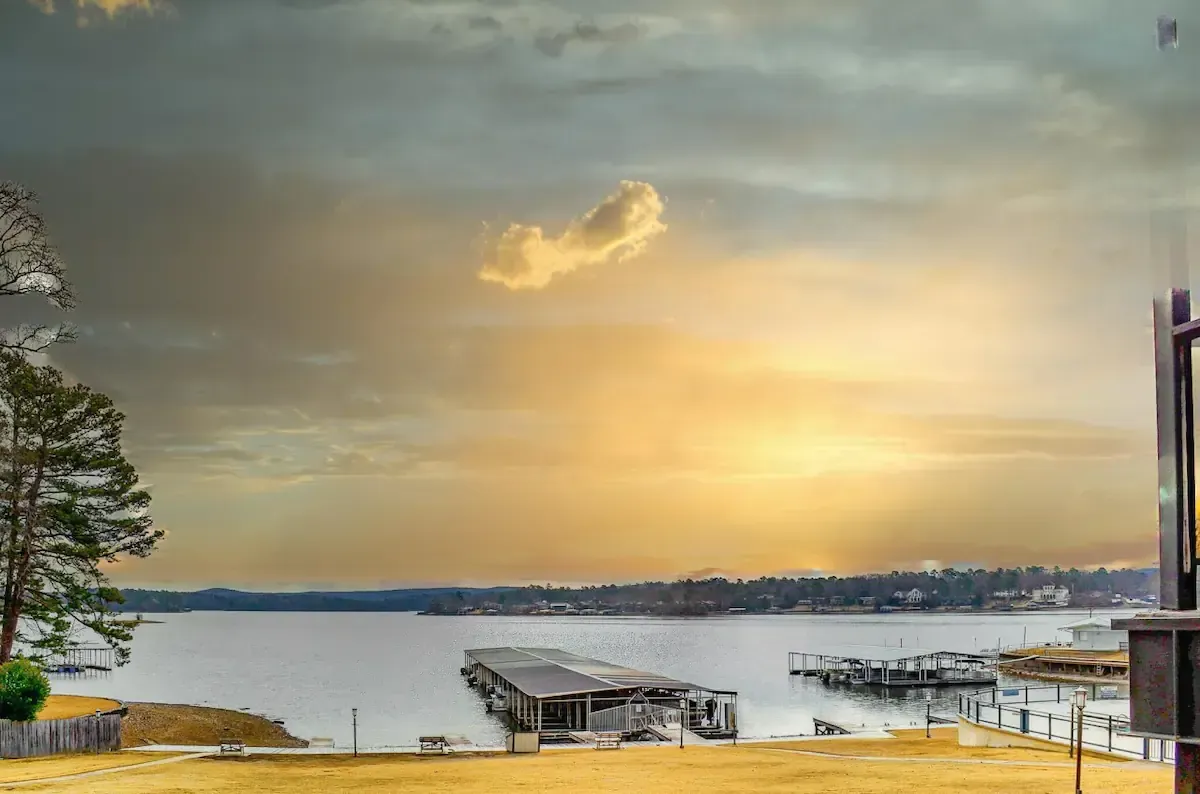 A sunset over a large body of water with a dock in the foreground.