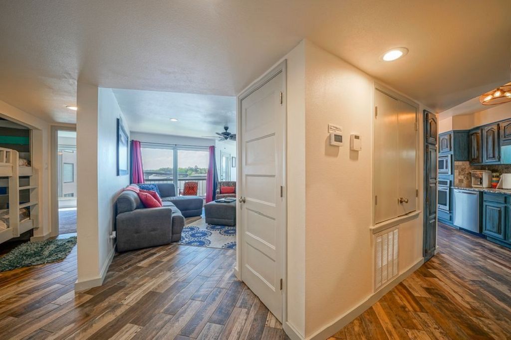 A hallway leading to a living room and kitchen in a house.