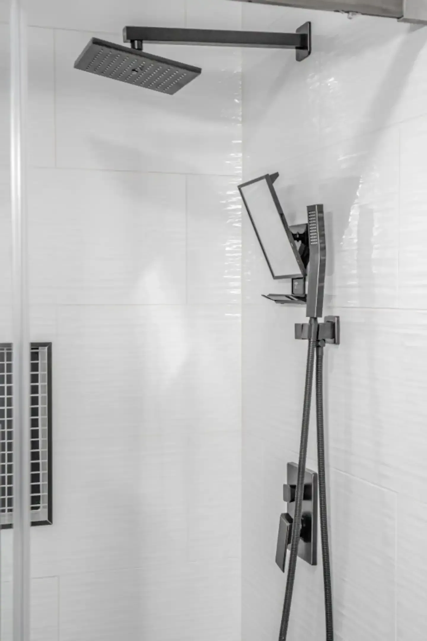 A black and white photo of a shower head in a bathroom.