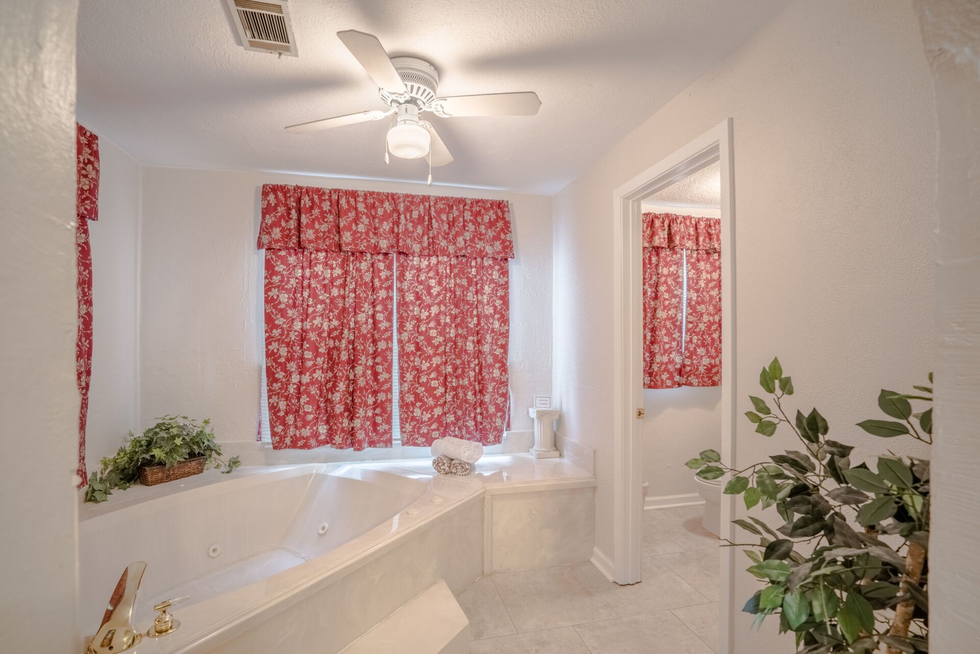 A bathroom with a tub and a ceiling fan