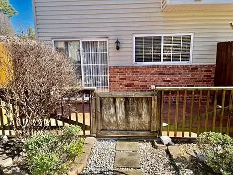 The backyard of a house with a wooden fence and a sliding glass door.