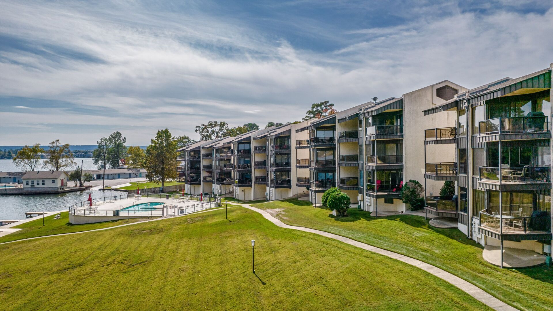 An aerial view of a large apartment building next to a body of water.