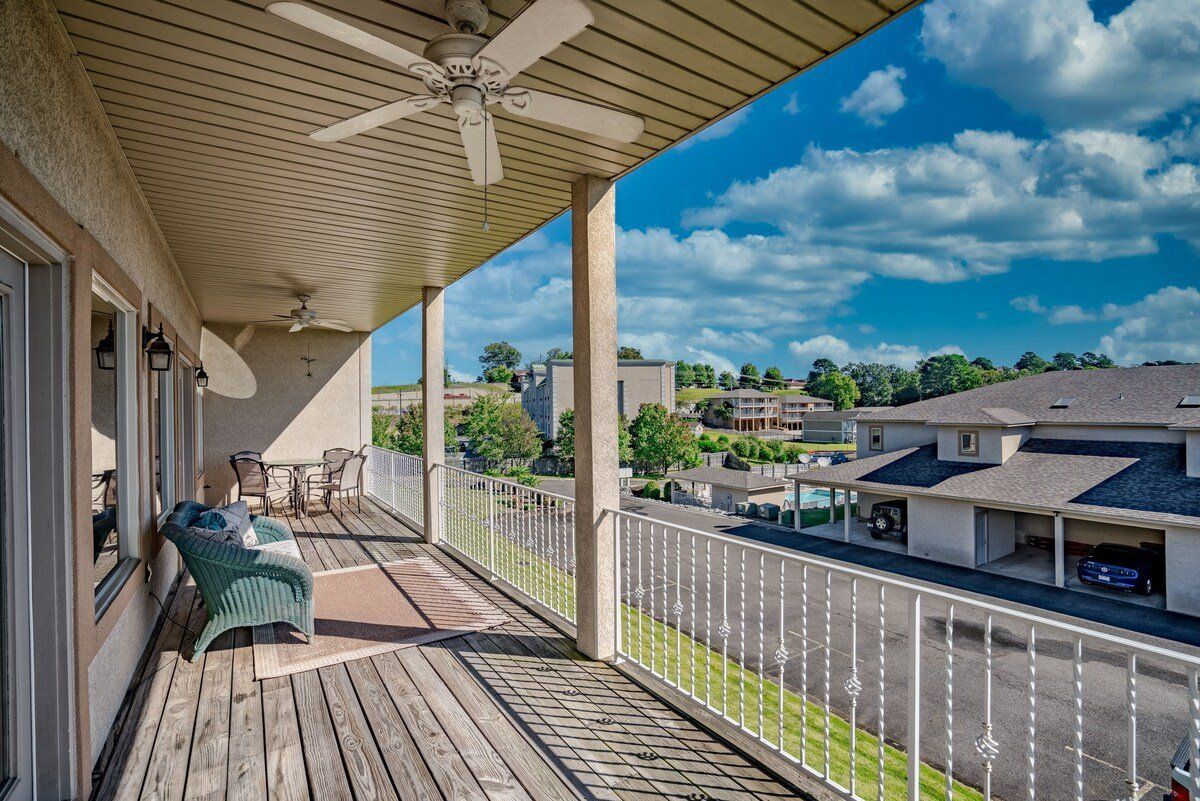 A balcony with a ceiling fan and a view of a residential area.