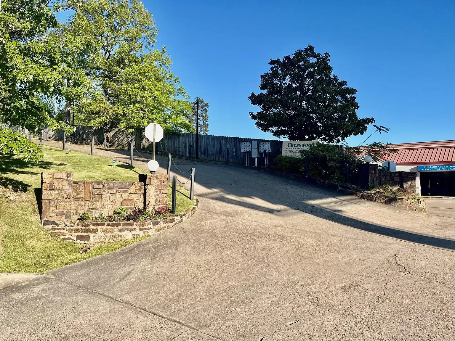 A gravel road leading to a house with a sign that says no parking