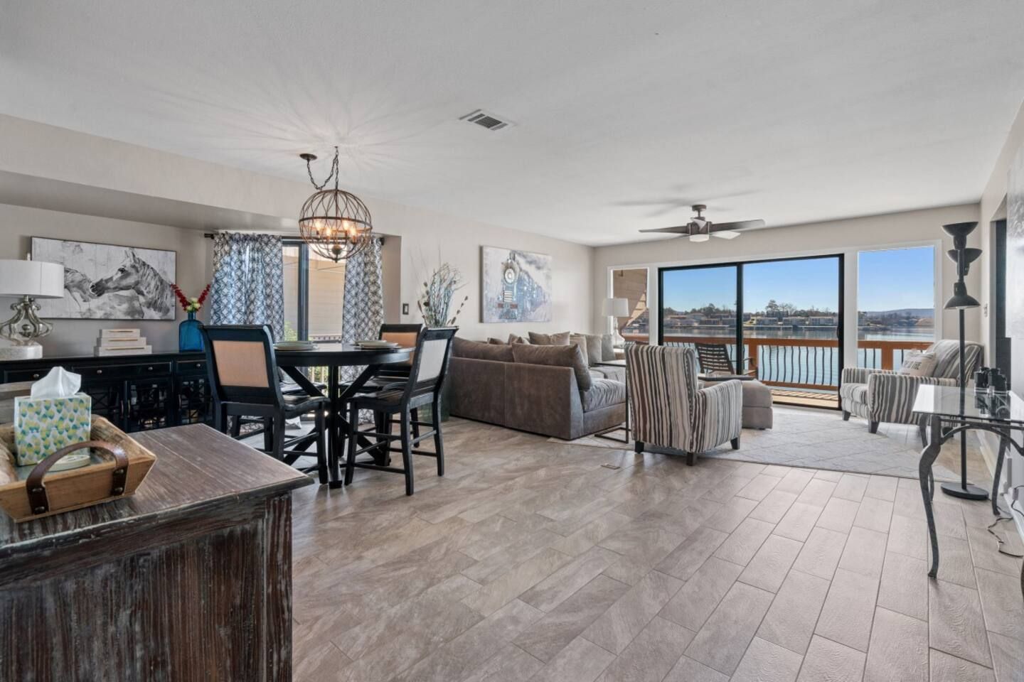 A living room filled with furniture and a table with a view of the water.