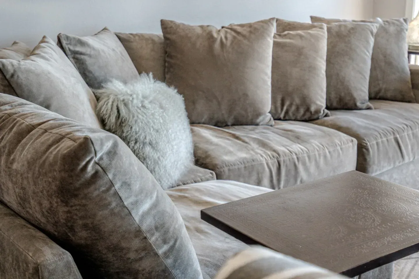 A couch with a lot of pillows on it in a living room.