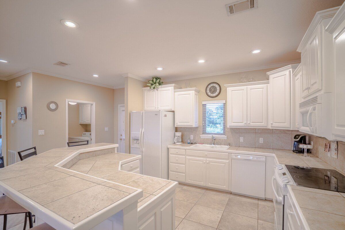 A kitchen with white cabinets and granite counter tops.