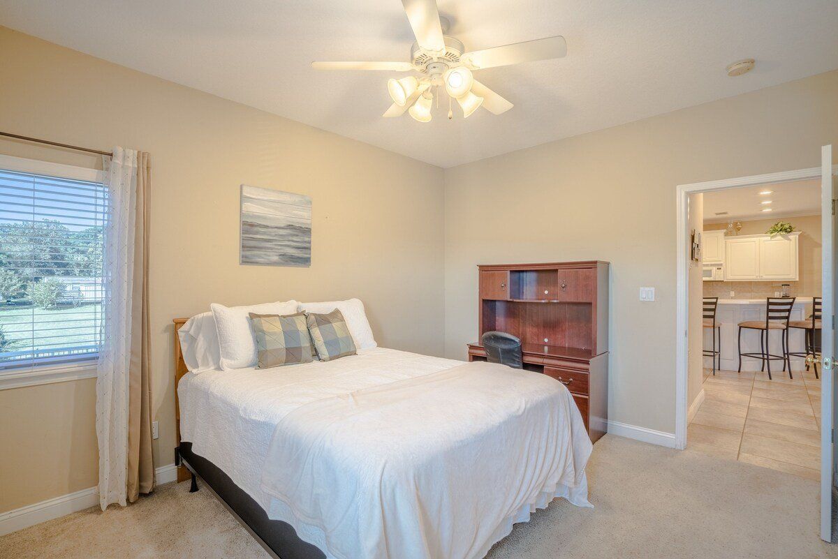 A bedroom with a king size bed and a ceiling fan.
