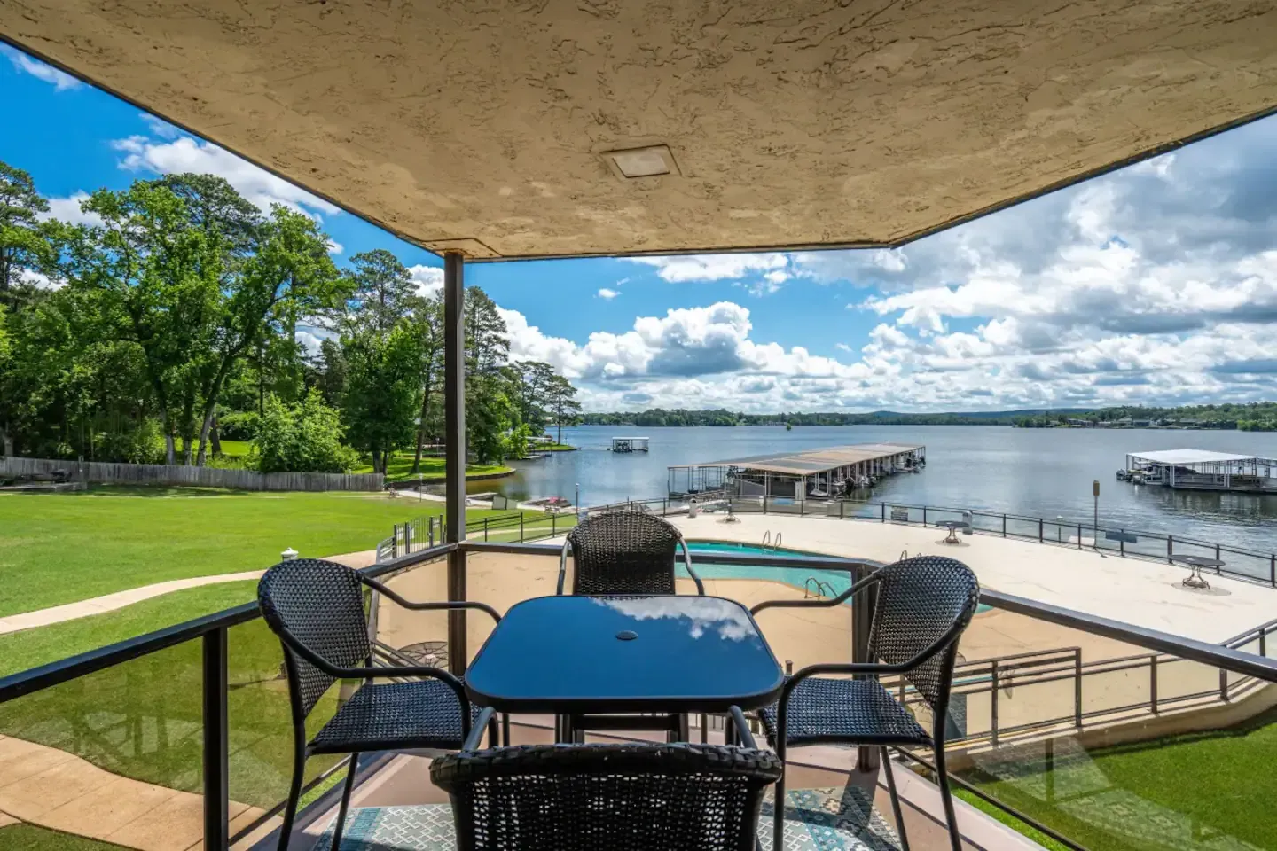 A balcony with a table and chairs overlooking a lake.